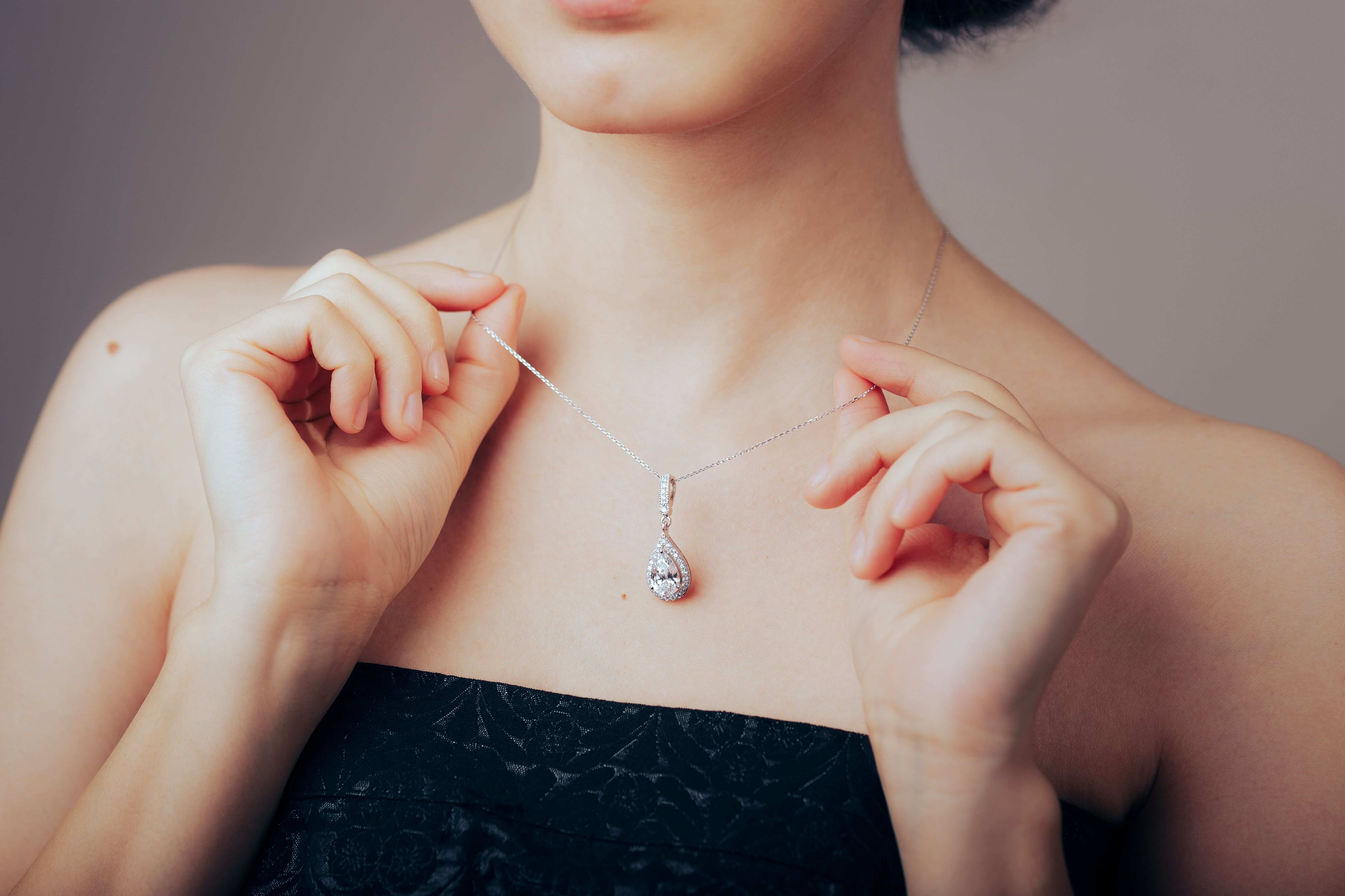 Image of a women wearing a strapless black dress and diamond necklace