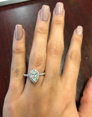 pear halo engagement ring on hand