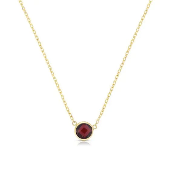 Image of round garnet solitaire pendant set in yellow gold